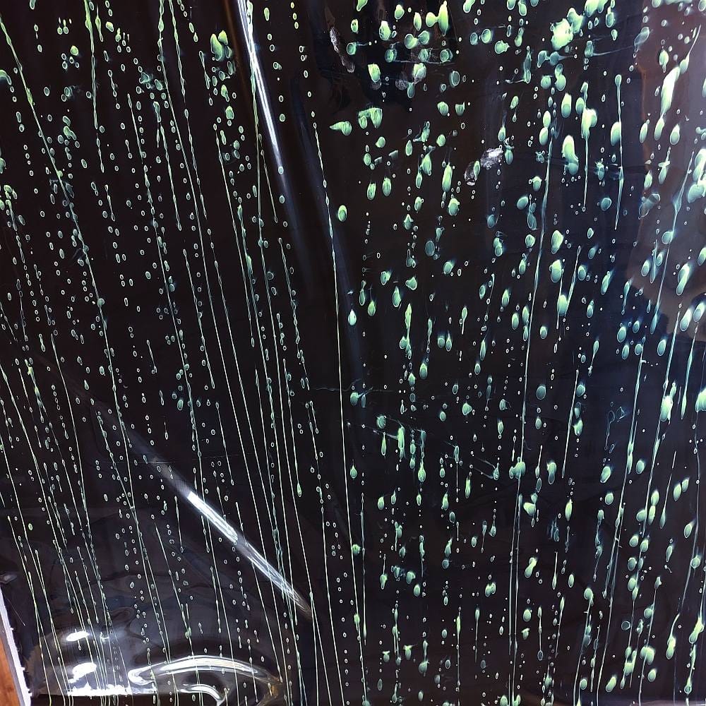 neon active splatters on a black latex sheet