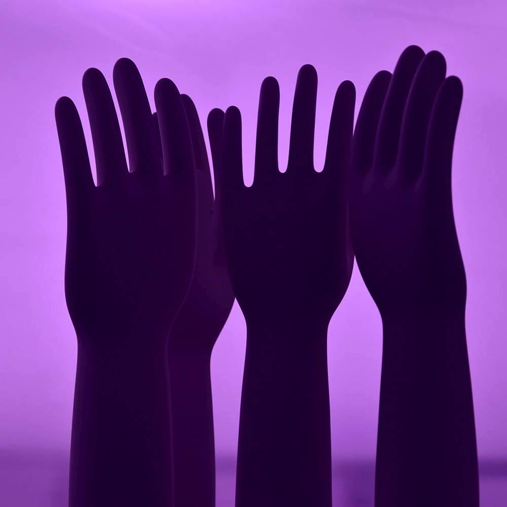 glove formers on a pink background
