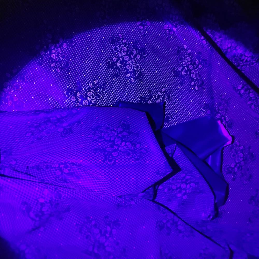 lace pattern on a dark latex sheet in UV light