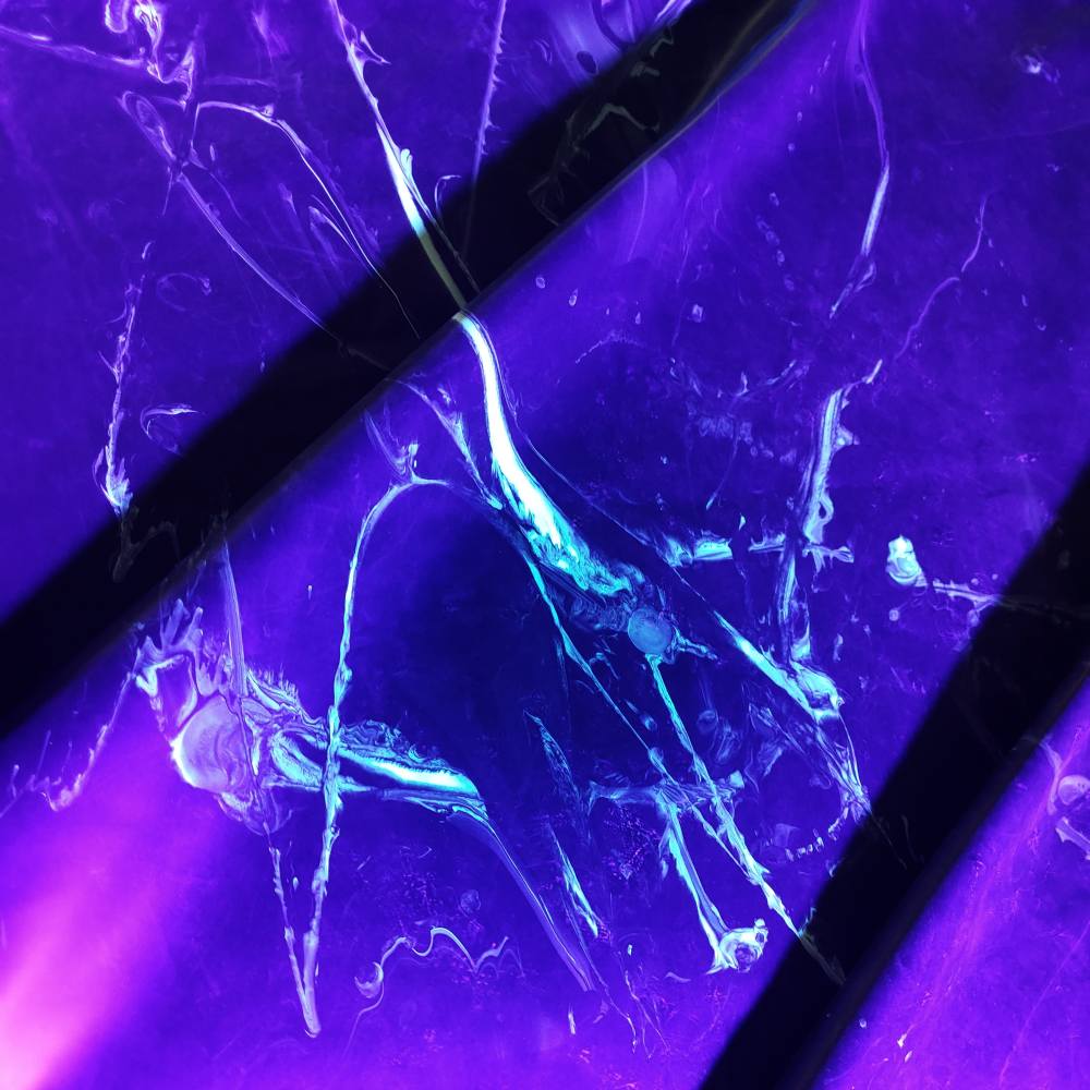 black latex sheet with neon green strokes under uv light